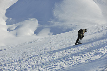 Image showing freestyle snowboarder jump and ride