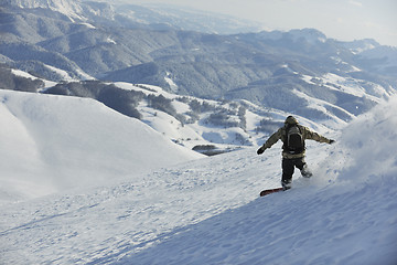 Image showing freestyle snowboarder jump and ride