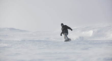 Image showing freestyle snowboarder jump and ride