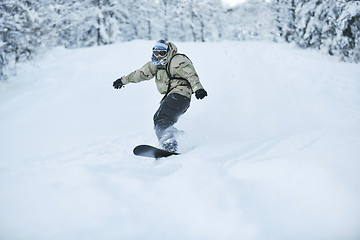 Image showing freestyle snowboarder jump and ride