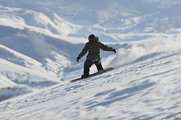 Image showing freestyle snowboarder jump and ride