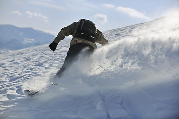 Image showing freestyle snowboarder jump and ride