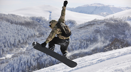 Image showing freestyle snowboarder jump and ride