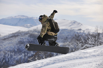 Image showing freestyle snowboarder jump and ride