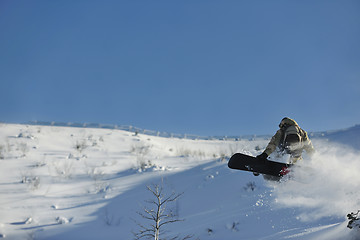 Image showing freestyle snowboarder jump and ride