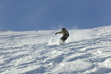 Image showing freestyle snowboarder jump and ride