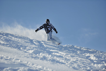 Image showing freestyle snowboarder jump and ride