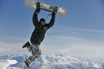 Image showing freestyle snowboarder jump and ride