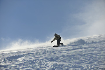 Image showing freestyle snowboarder jump and ride