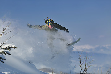 Image showing freestyle snowboarder jump and ride