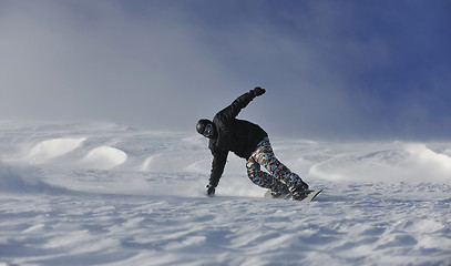 Image showing freestyle snowboarder jump and ride