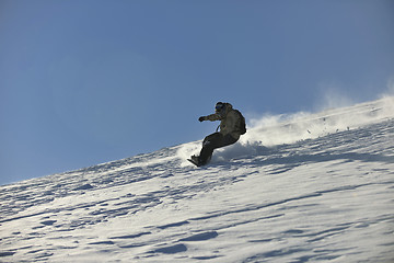 Image showing freestyle snowboarder jump and ride