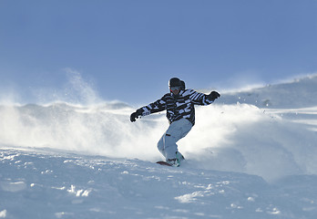 Image showing freestyle snowboarder jump and ride