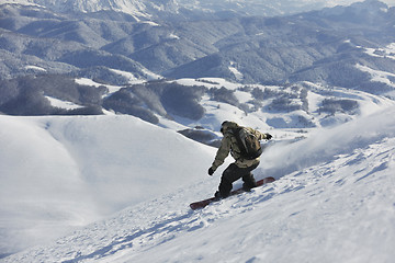 Image showing freestyle snowboarder jump and ride