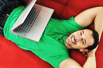 Image showing man relaxing on sofa and work on laptop computerman relaxing on
