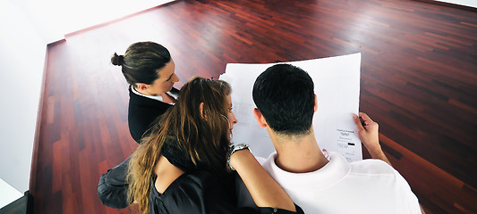 Image showing happy young couple buying new home with real estate agent