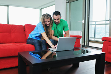 Image showing happy couple have fun and work on laptop at home