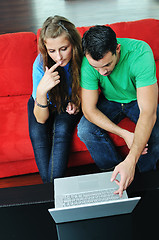 Image showing happy couple have fun and work on laptop at home