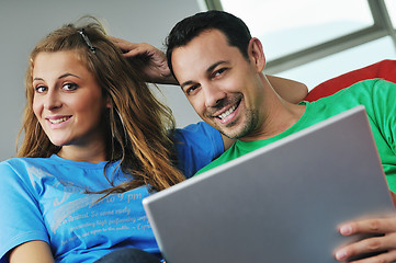 Image showing happy couple have fun and work on laptop at home