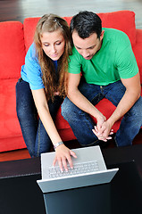 Image showing happy couple have fun and work on laptop at home