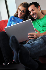 Image showing happy couple have fun and work on laptop at home