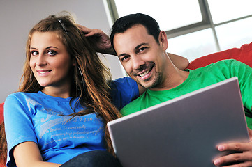 Image showing happy couple have fun and work on laptop at home