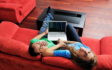 Image showing happy couple have fun and work on laptop at home