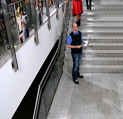 Image showing young business man standing on stairs and hold laptop