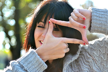 Image showing Young woman pretending to see throuhg a  lens