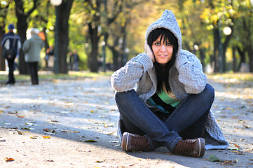 Image showing brunette Cute young woman  sitting  in nature