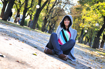 Image showing brunette Cute young woman  sitting  in nature