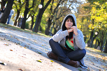 Image showing brunette Cute young woman  sitting  in nature