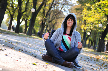 Image showing brunette Cute young woman  sitting  in nature