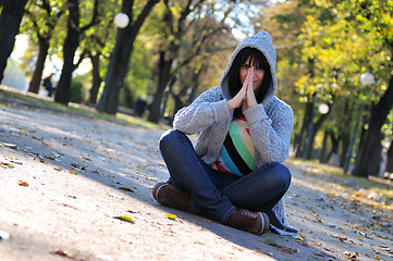 Image showing Cute young woman sitting outdoors in nature