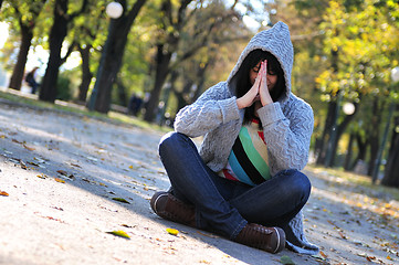 Image showing Cute young woman sitting outdoors in nature