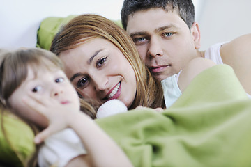 Image showing happy family relaxing in bed