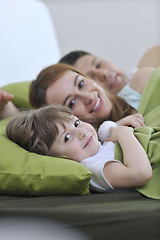 Image showing happy family relaxing in bed