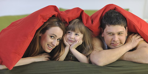 Image showing happy family relaxing in bed