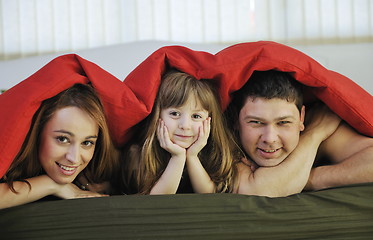 Image showing happy family relaxing in bed