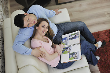 Image showing couple looking old pictures in photo album at home