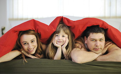 Image showing happy family relaxing in bed