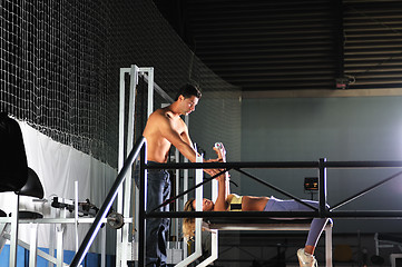 Image showing woman in the fitness gim working out with personal trainer