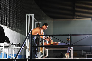 Image showing woman in the fitness gim working out with personal trainer