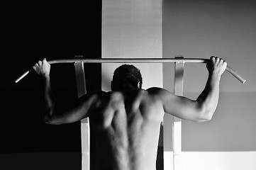 Image showing young man with strong arms working out in gym