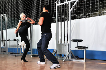 Image showing woman in the fitness gim working out with personal trainer