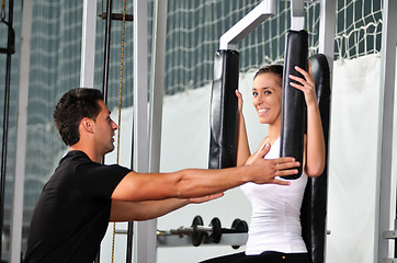 Image showing woman in the fitness gim working out with personal trainer