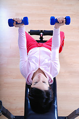 Image showing .a young woman weightlifting at gym 