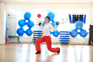 Image showing .a young woman weightlifting at gym 