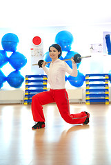 Image showing .a young woman weightlifting at gym 