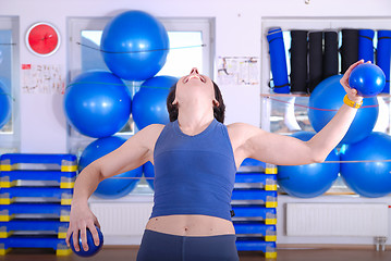 Image showing .happy young woman exercising in a gym